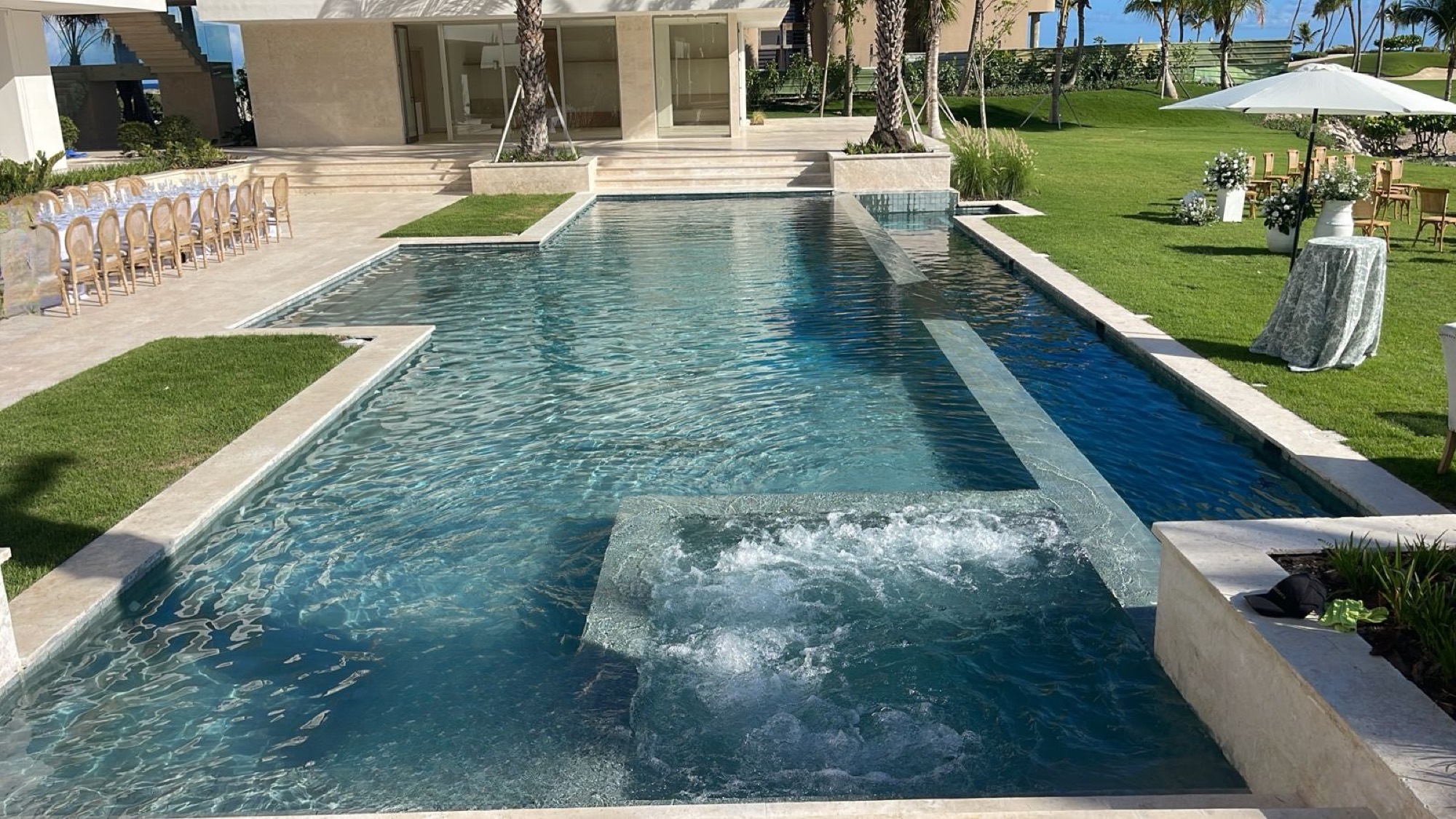 Piscina terminada por HydroMaster en Cap Cana, con jacuzzi elevado y jardín