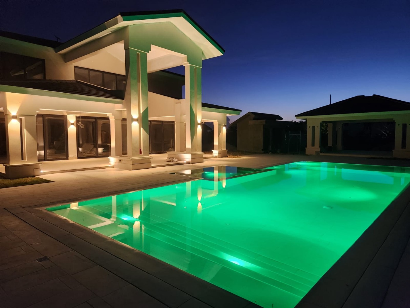 Piscina iluminada en verde de noche